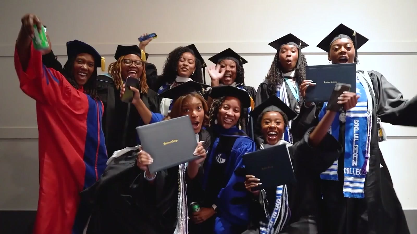 Spelman graduates celebrating with their diplomas